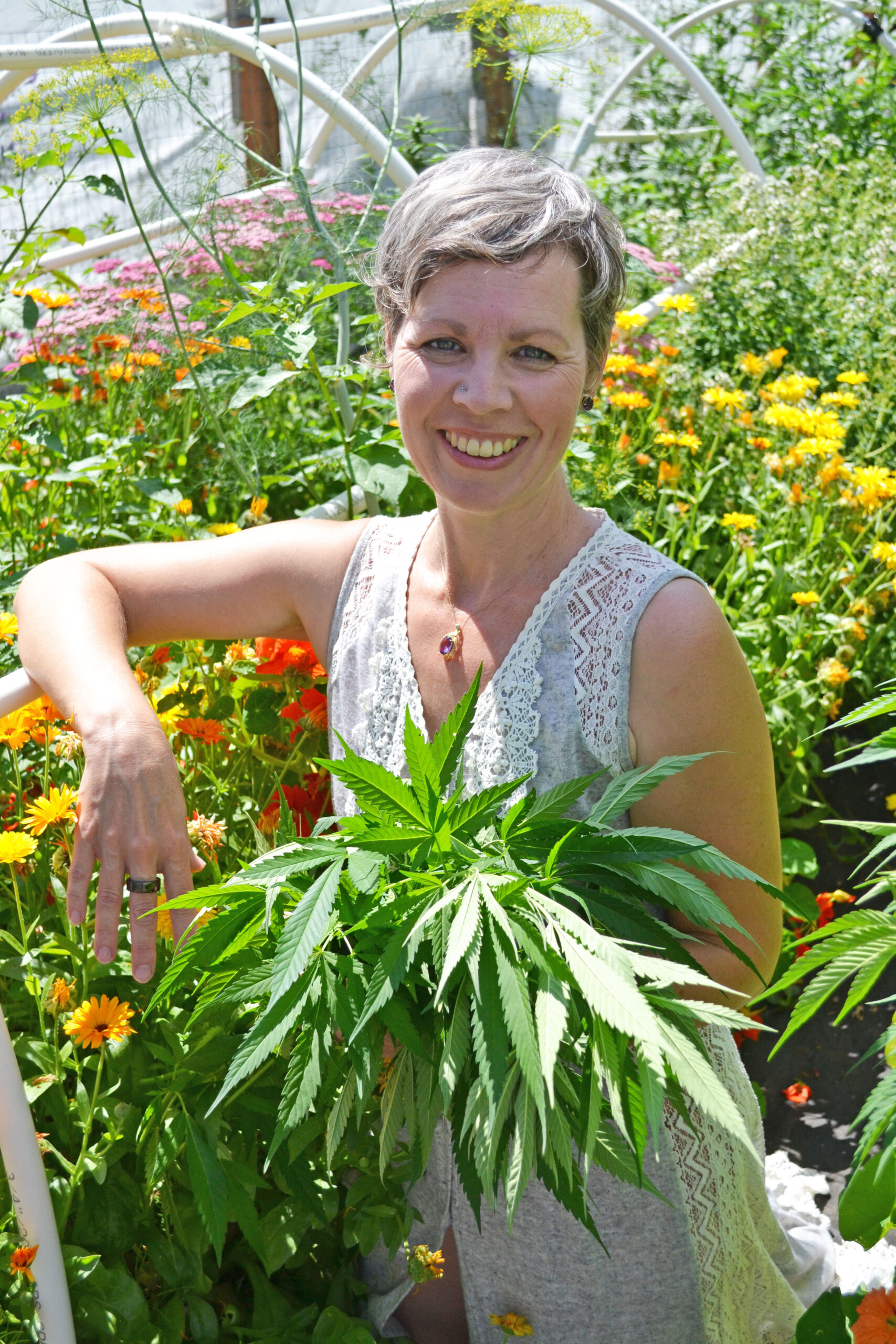 Terese-Bowors-Specialized-Cannabis-Coaching Services cannabis coach in the cannabis garden holding cannabis plants